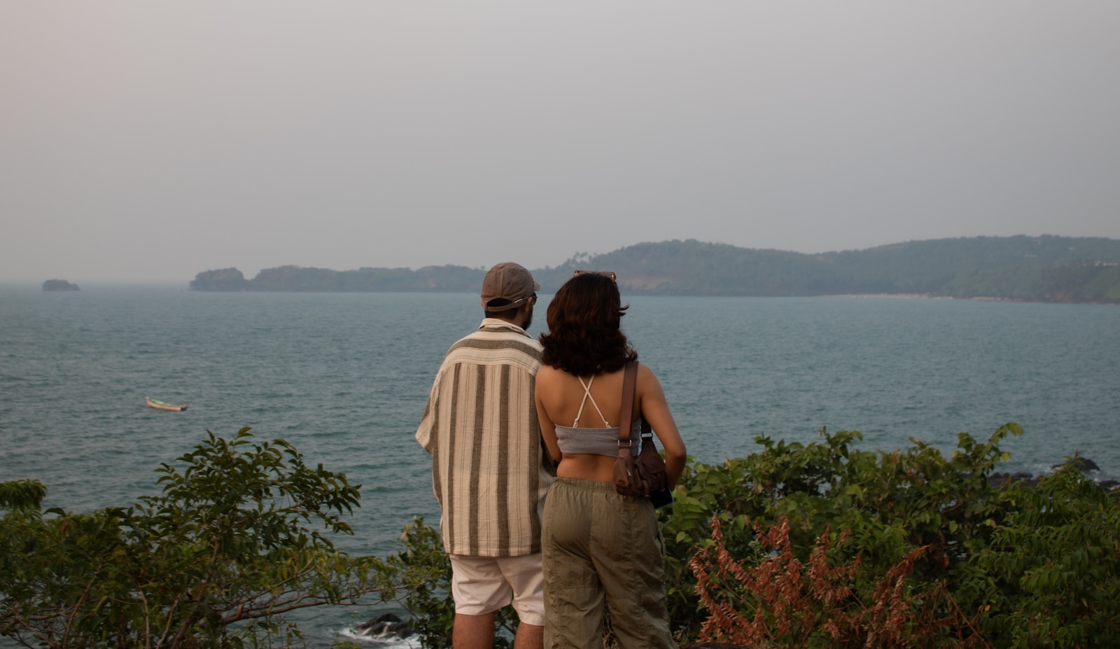 Couple looking out at the ocean from a clifftop.